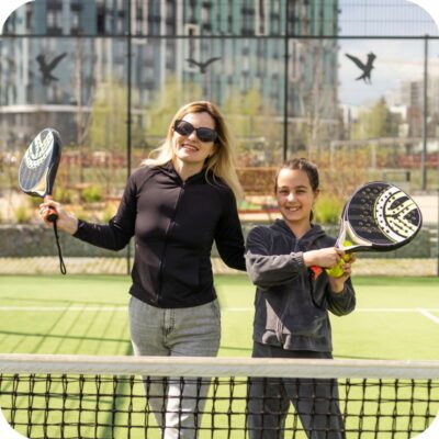 A teacher playing Padel with one of her students